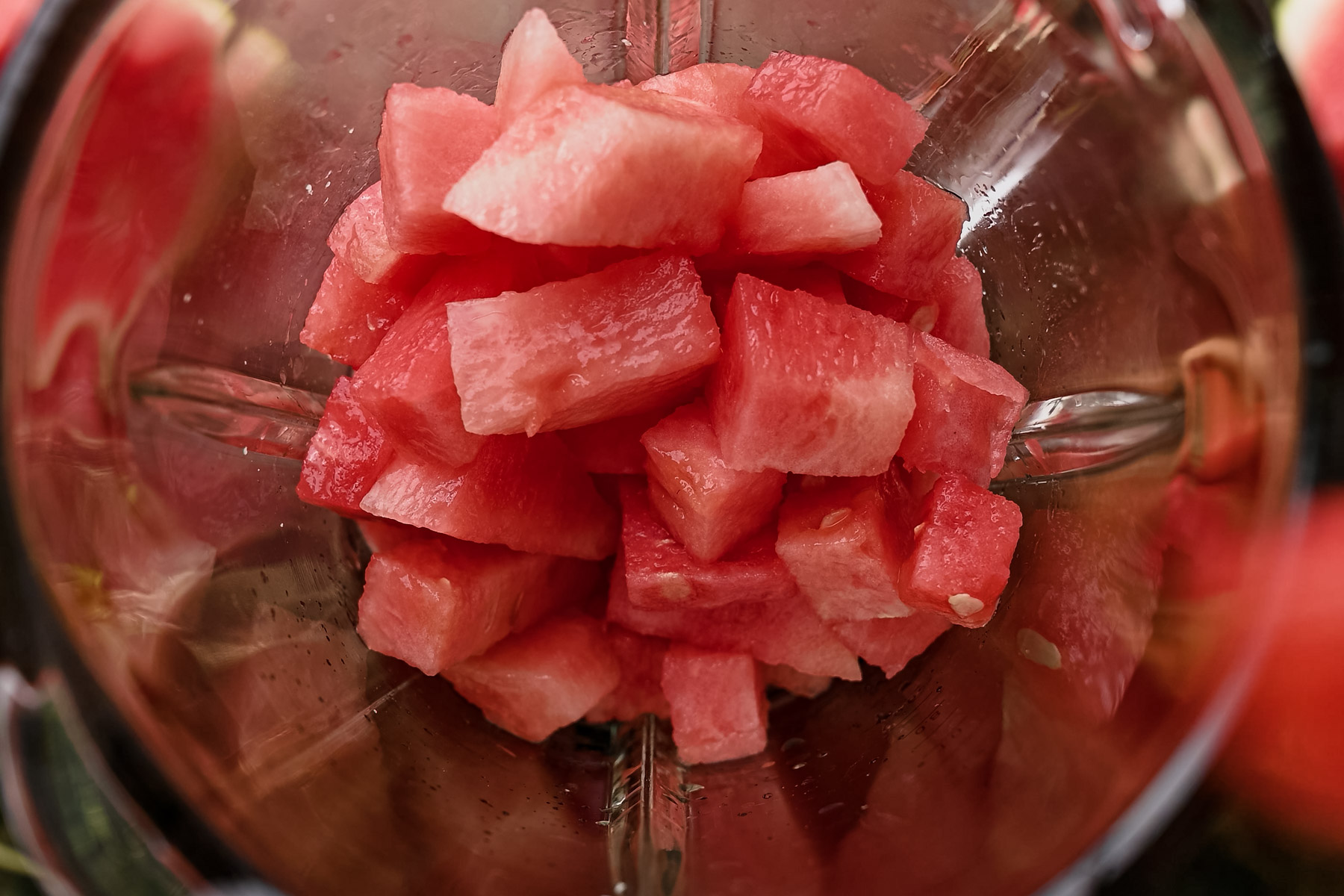 Close-up of a blender filled with chopped watermelon pieces.
