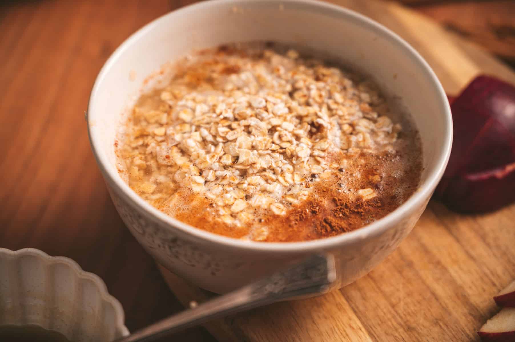 Water poured over apple cinnamon oatmeal in a bowl.