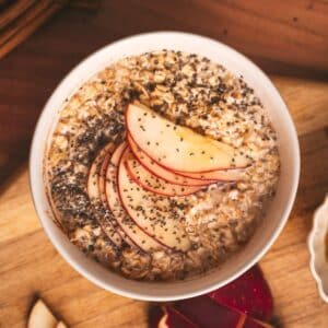 Flatlay photo of apple cinnamon oatmeal with sliced apples fanned out on top.
