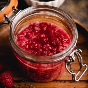 Homemade red chia jam in a glass jar.