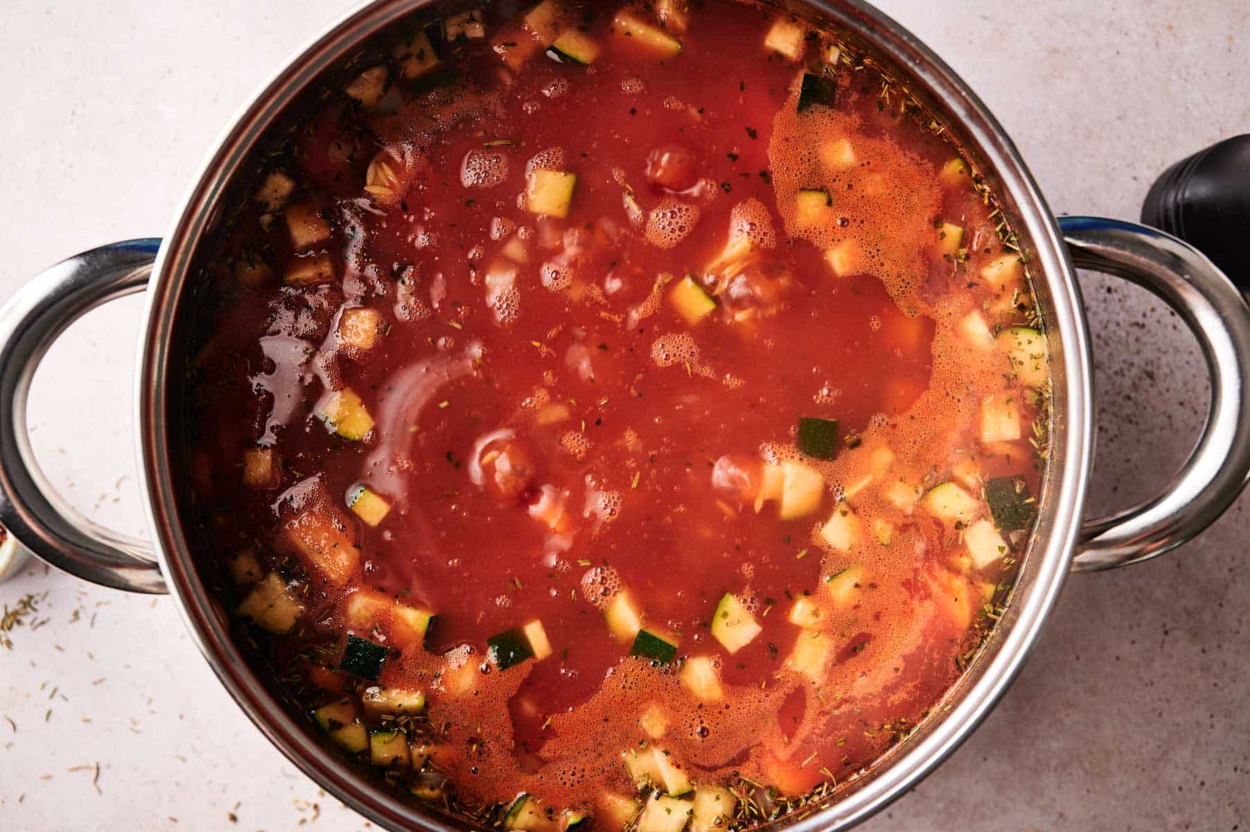 Vegetables, tomato sauce, added to stainless steel cooking pot.