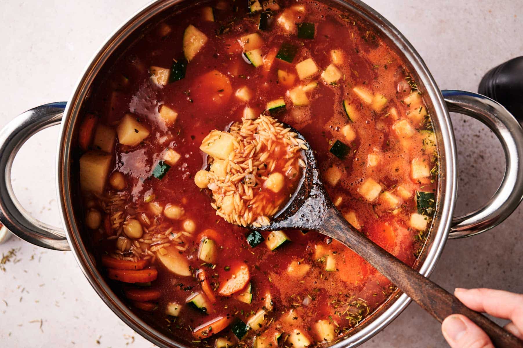 Vegetables, tomato sauce, added to stainless steel cooking pot.