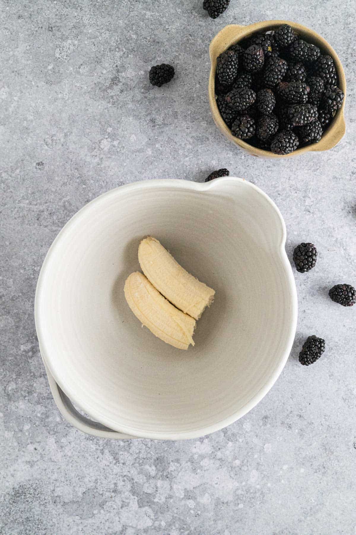 Adding banana to a large bowl.