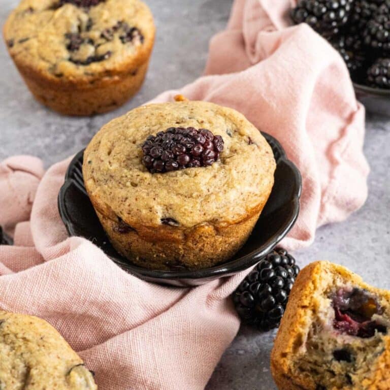 Homemade blackberry muffin in a small bowl with a pink napkin.