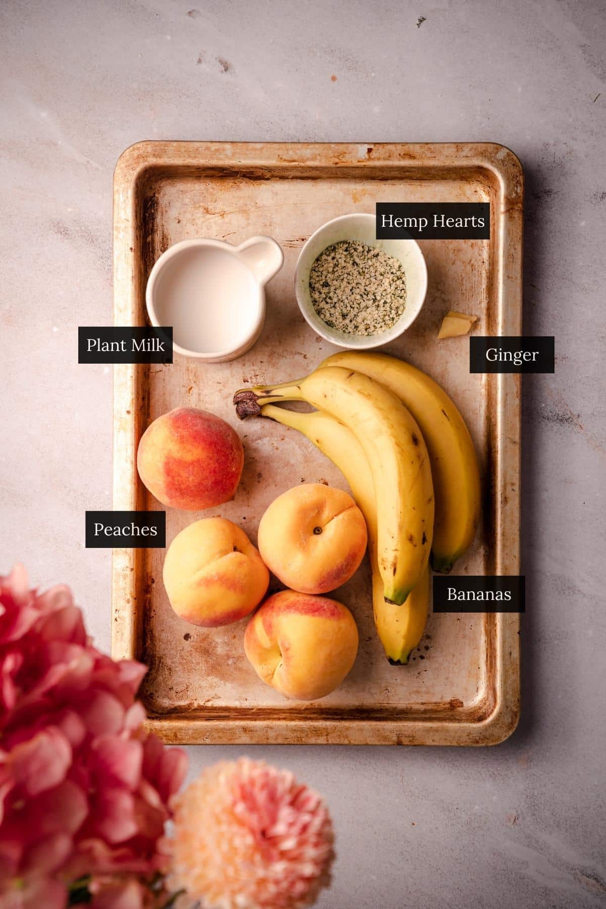 A tray with bananas, peaches, and a bowl of fruit.