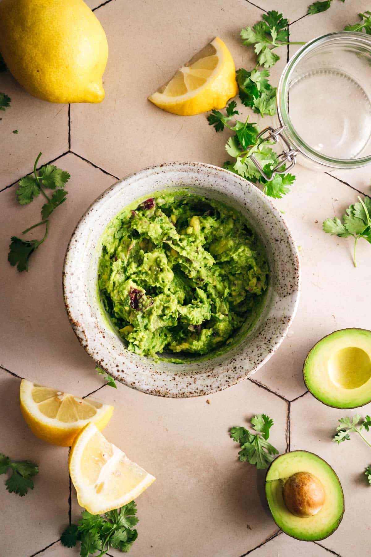 Scooping homemade lemon guacamole into a Le Parfait jar.