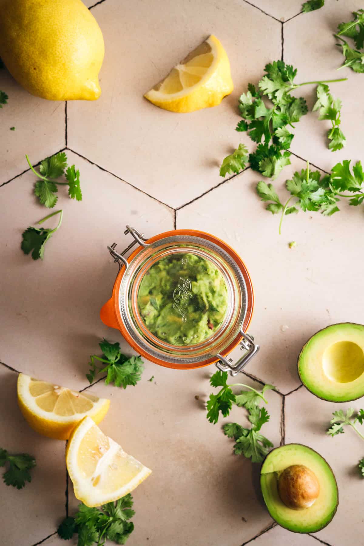 Sealing a glass jar full of the best guacamole recipe.