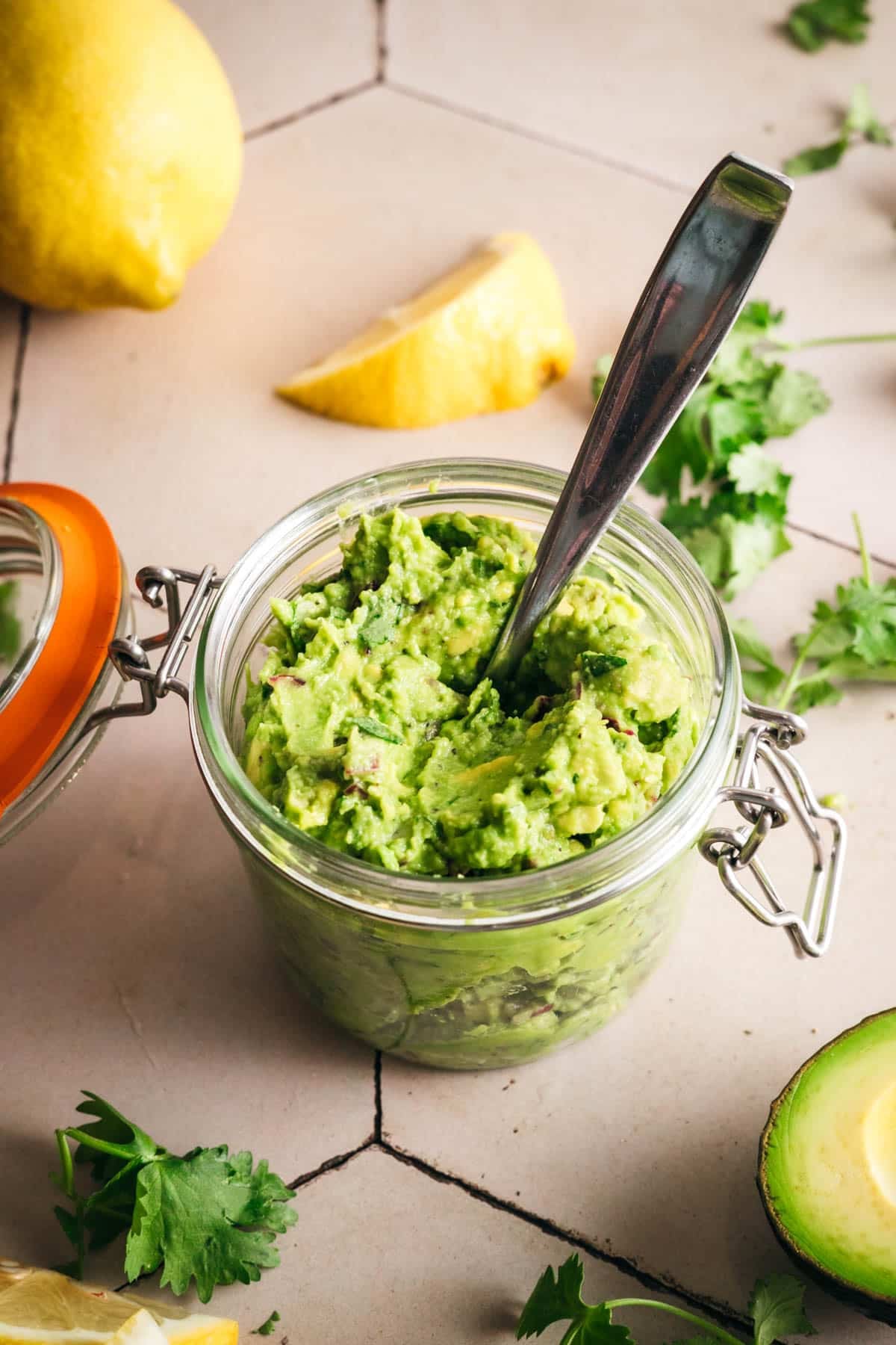 A jar of homemade guacamole with fresh lemon juice.