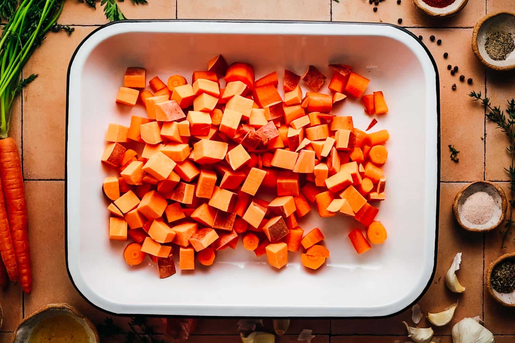 Chopped carrots added to a baking dish.