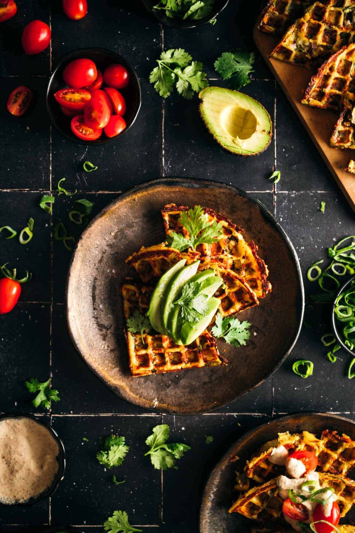 Mashed potato waffle with sliced avocado on top.