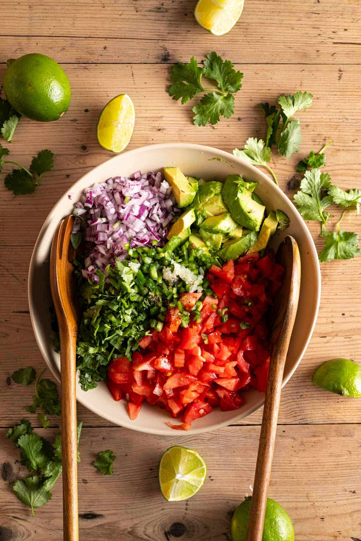 Mixing all the ingredients for pico de gallo with cubed avocado.