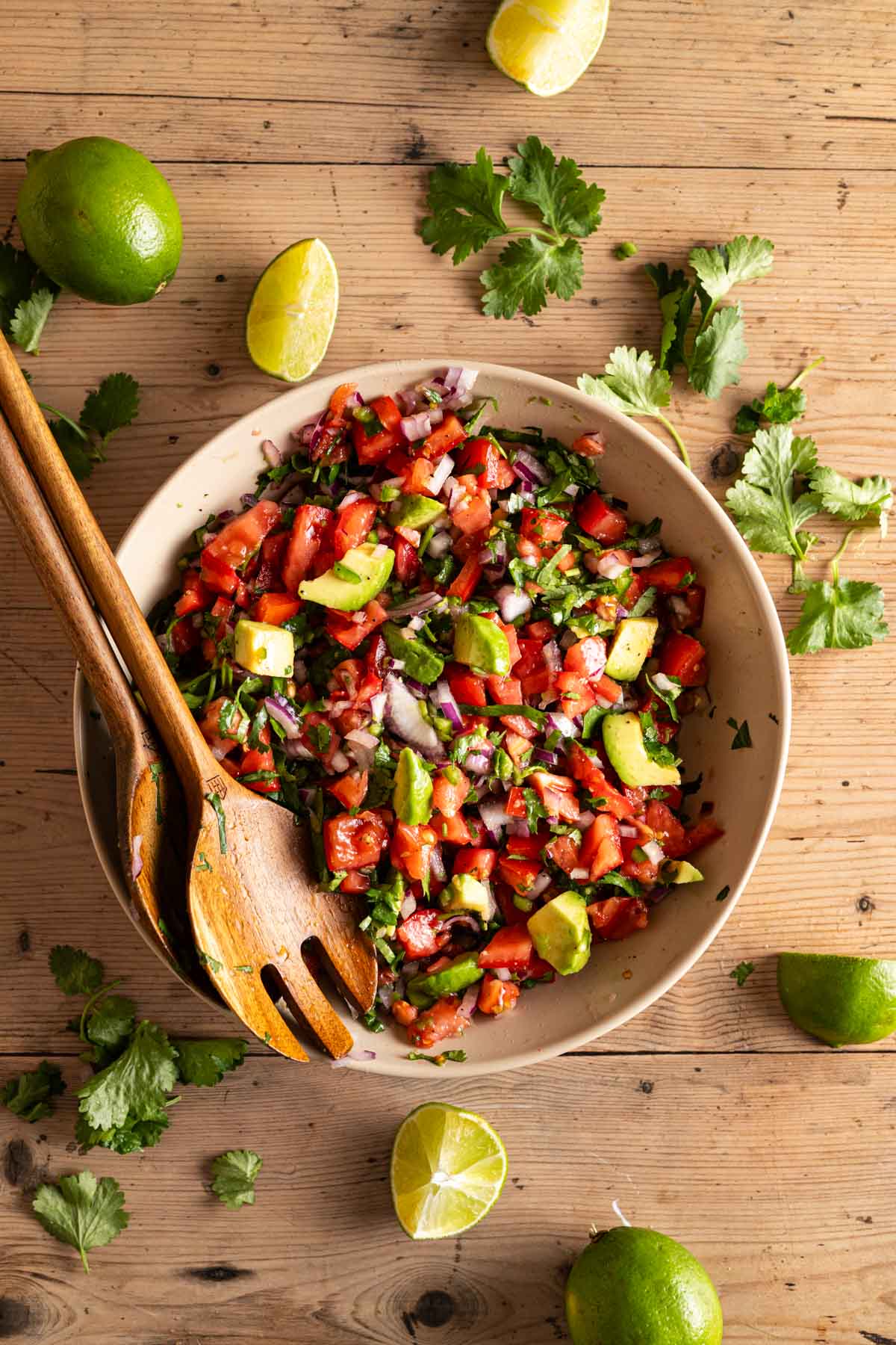 Mixing all the ingredients for pico de gallo with cubed avocado.