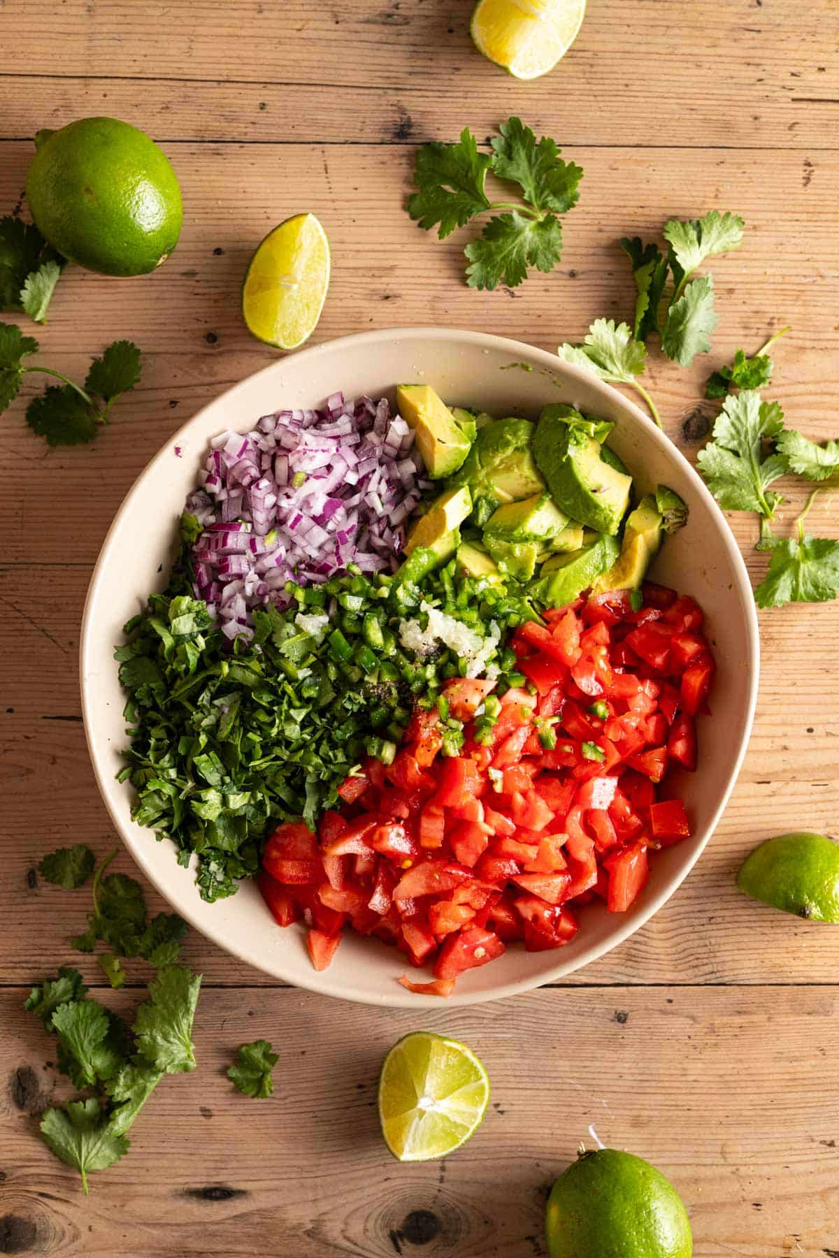 Mixing all the ingredients for pico de gallo with cubed avocado.