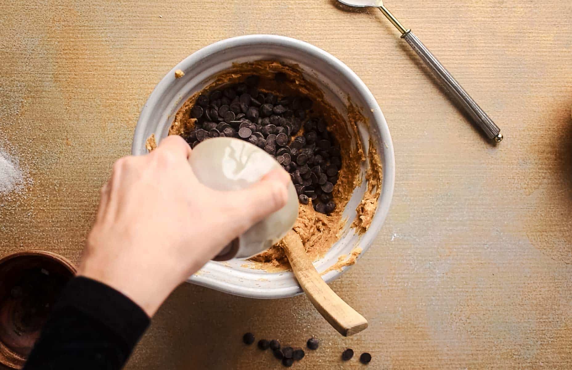 Adding chocolate chips to the pumpkin cookie dough.