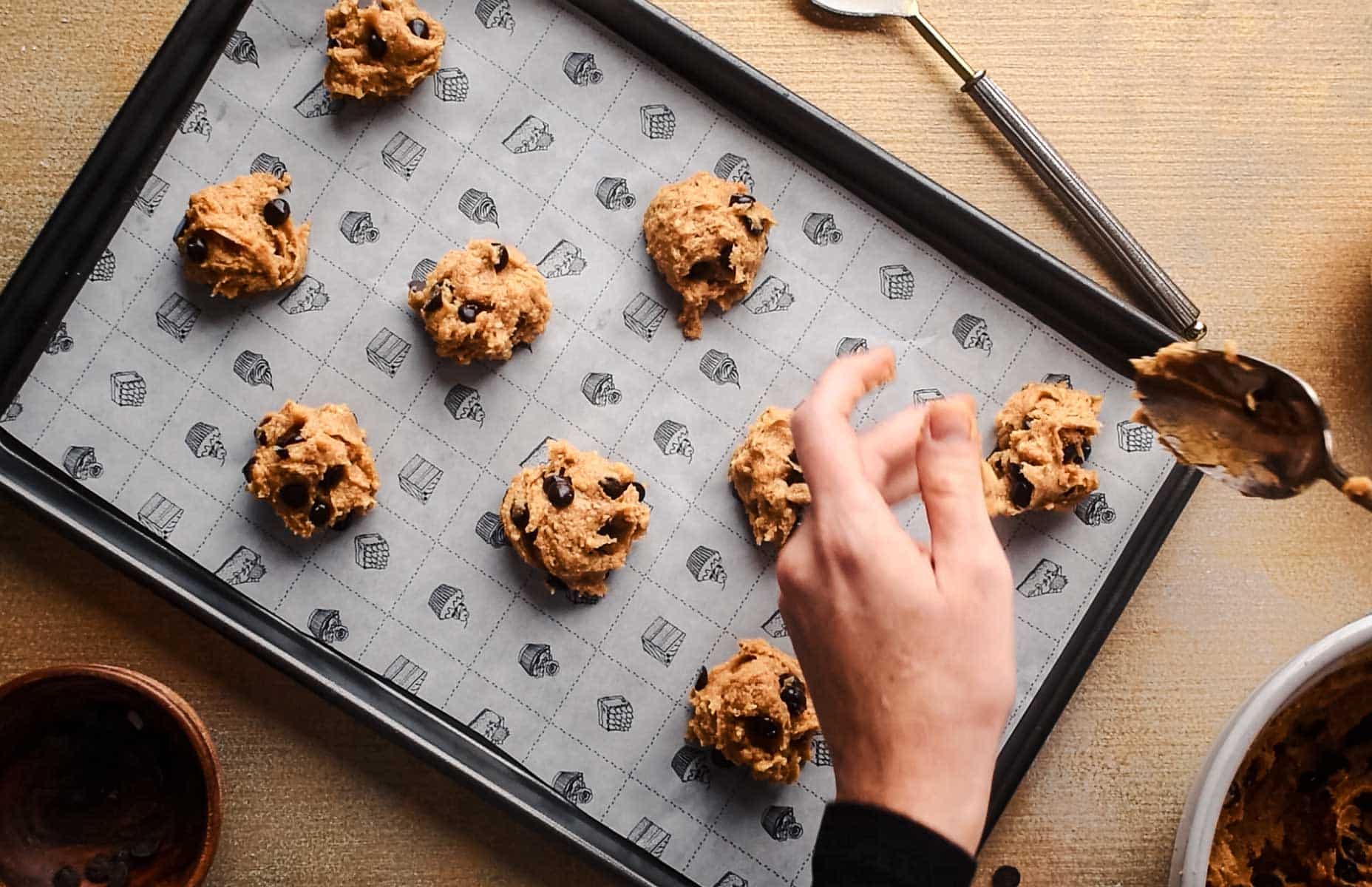 Chocolate chip pumpkin cookies formed on a baking sheet.
