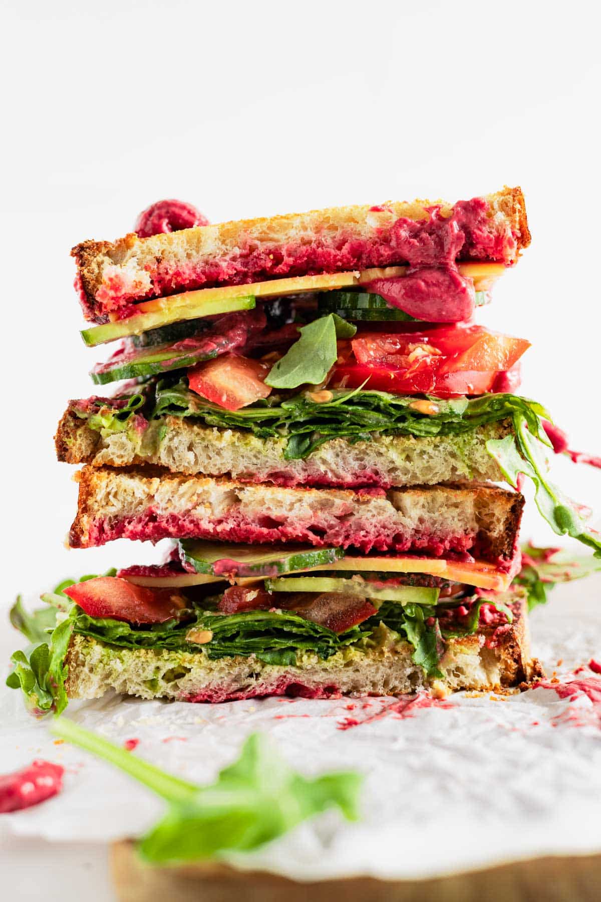 Hummus beet sandwich cut in half and stacked onto each other.