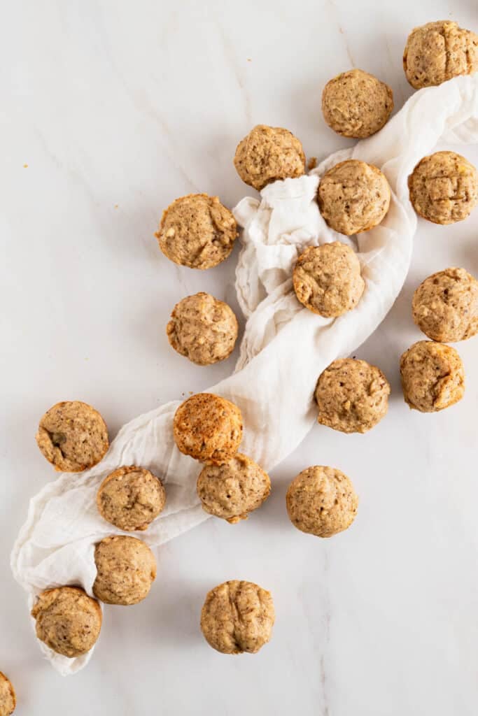 Baked banana mini muffins on a white marble counter.