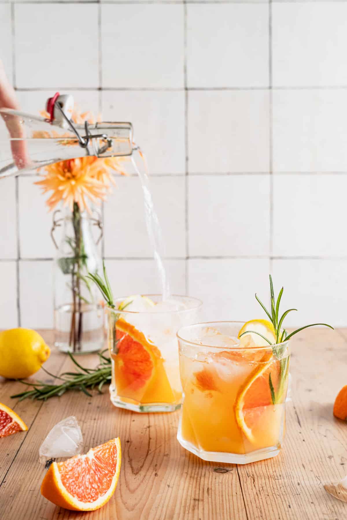 Adding sparking water to orange spritz drink.
