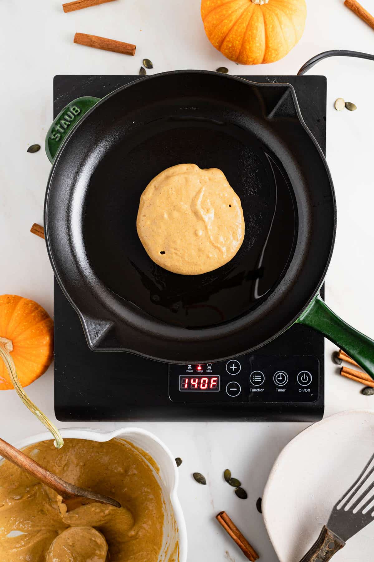 Cast iron skillet cooking pumpkin pancakes with protein powder.