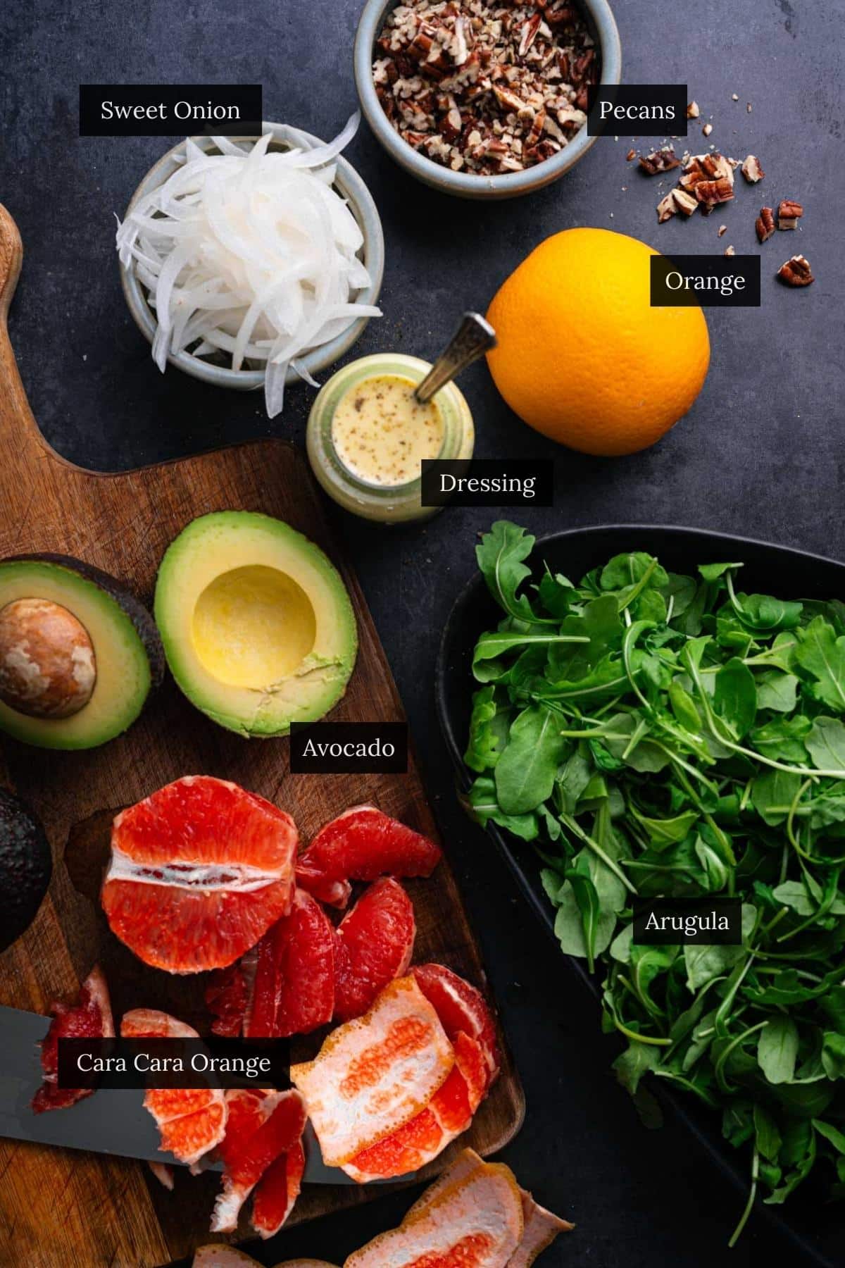 Ingredients for arugula citrus salad with each ingredient labeled.