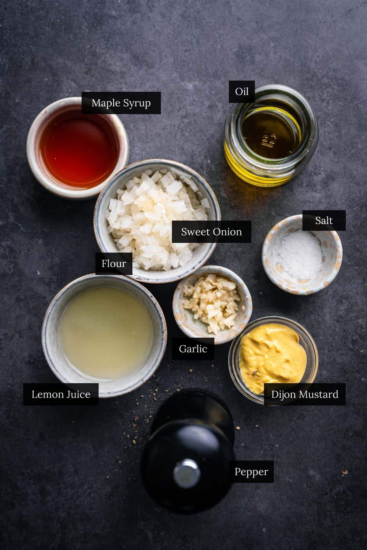 Ingredients for sweet onion citrus dressing on a dark gray counter with each ingredient labeled.