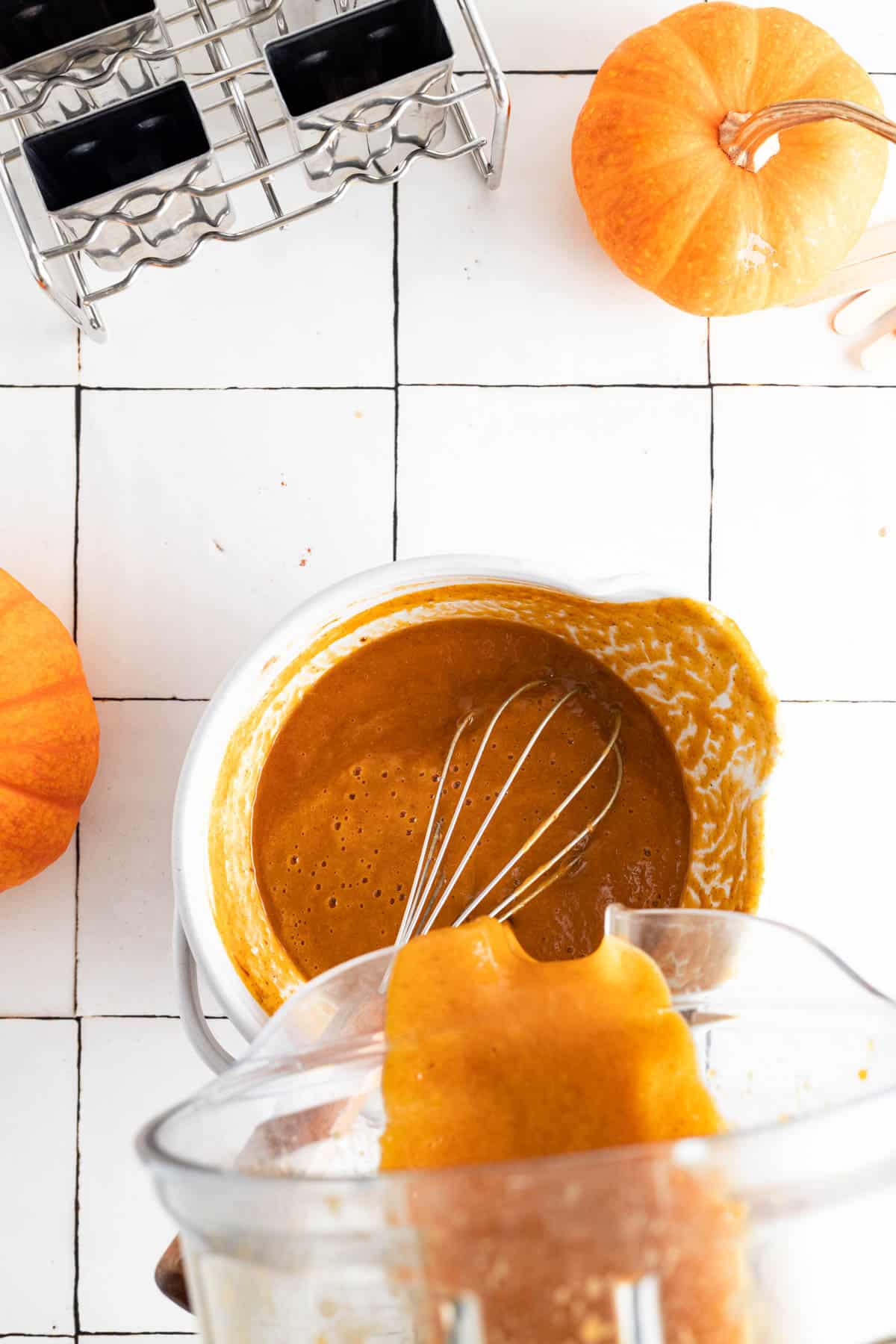 Pumpkin spice popsicles in a mixing bowl with a whisk sticking out.
