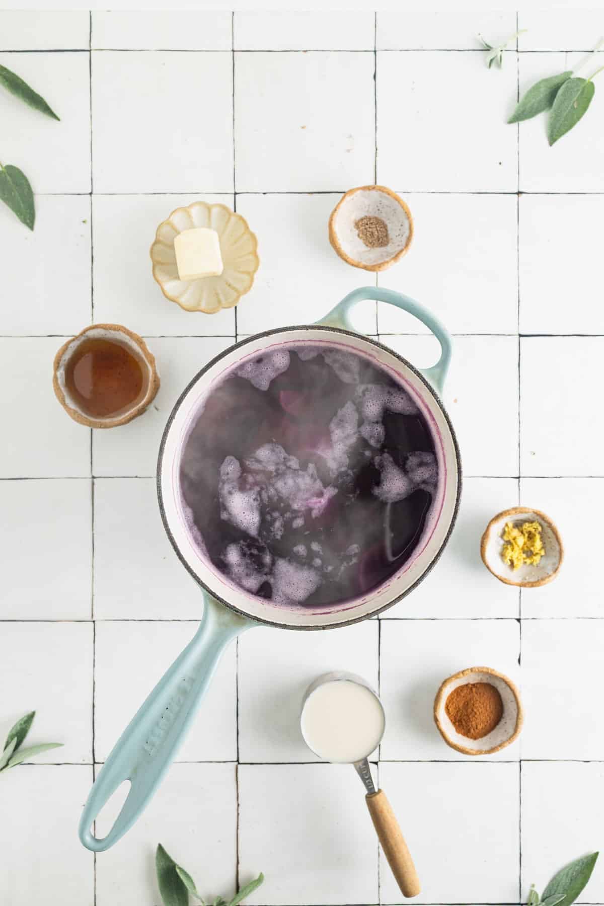 Chopped purple sweet potatoes in a saucepan covered in water cooking.