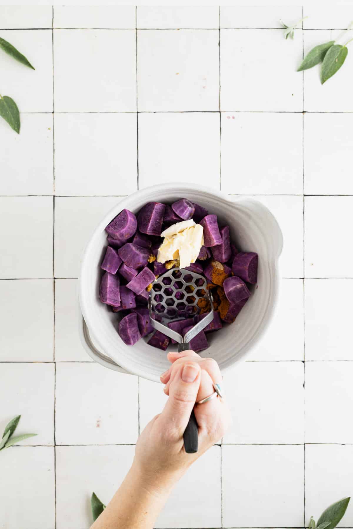 Mashing the ingredients for homemade vegan sweet potatoes.