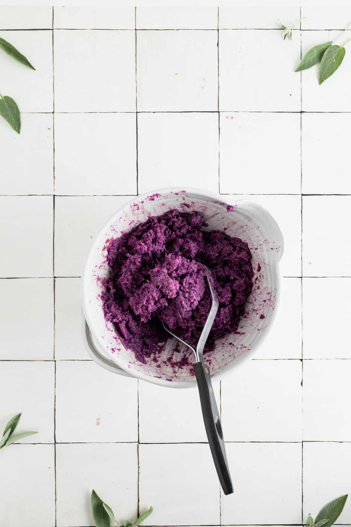 Mashing the ingredients for homemade vegan sweet potatoes.