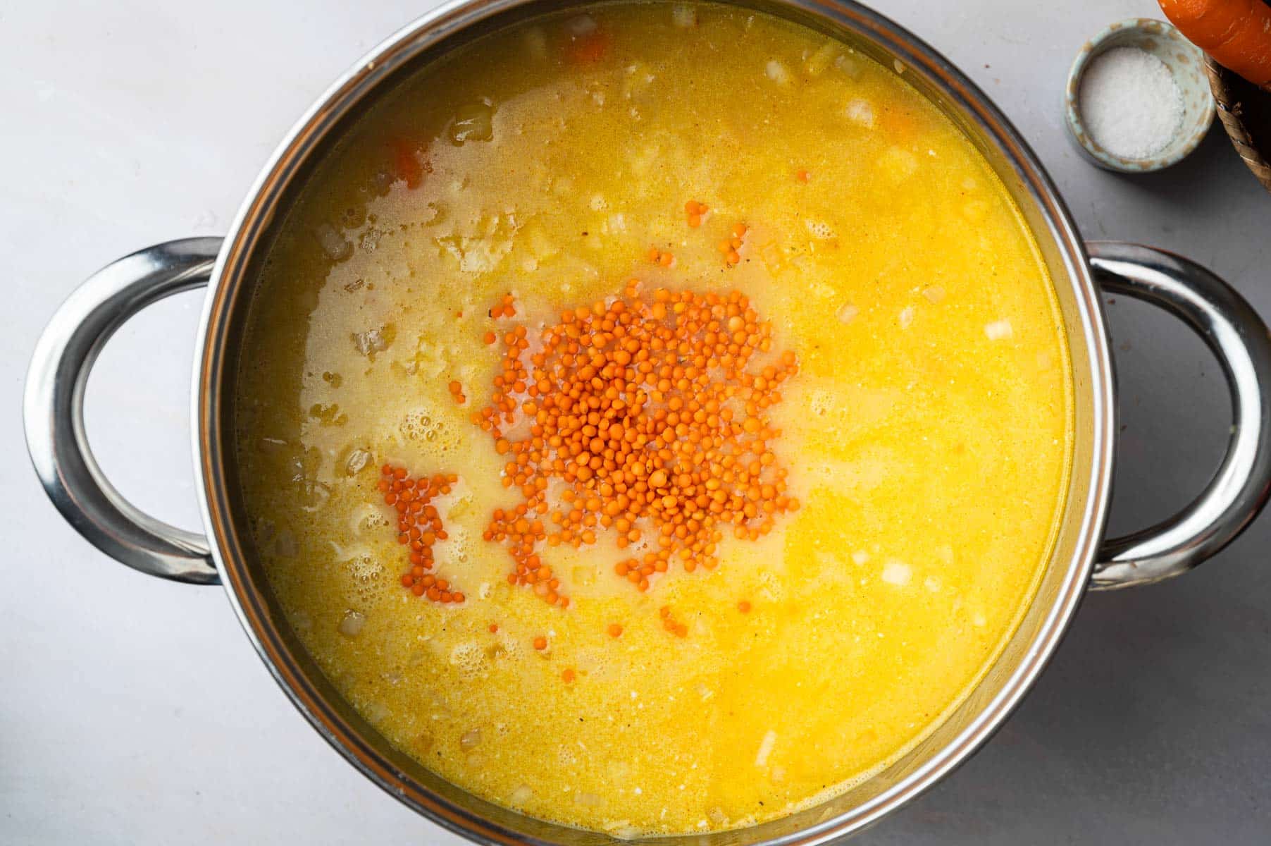 Adding lentils to the pot.