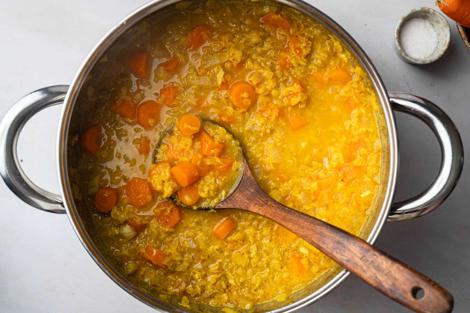 Veggies, lentils, and carrots cooking in the stainless steel pot.
