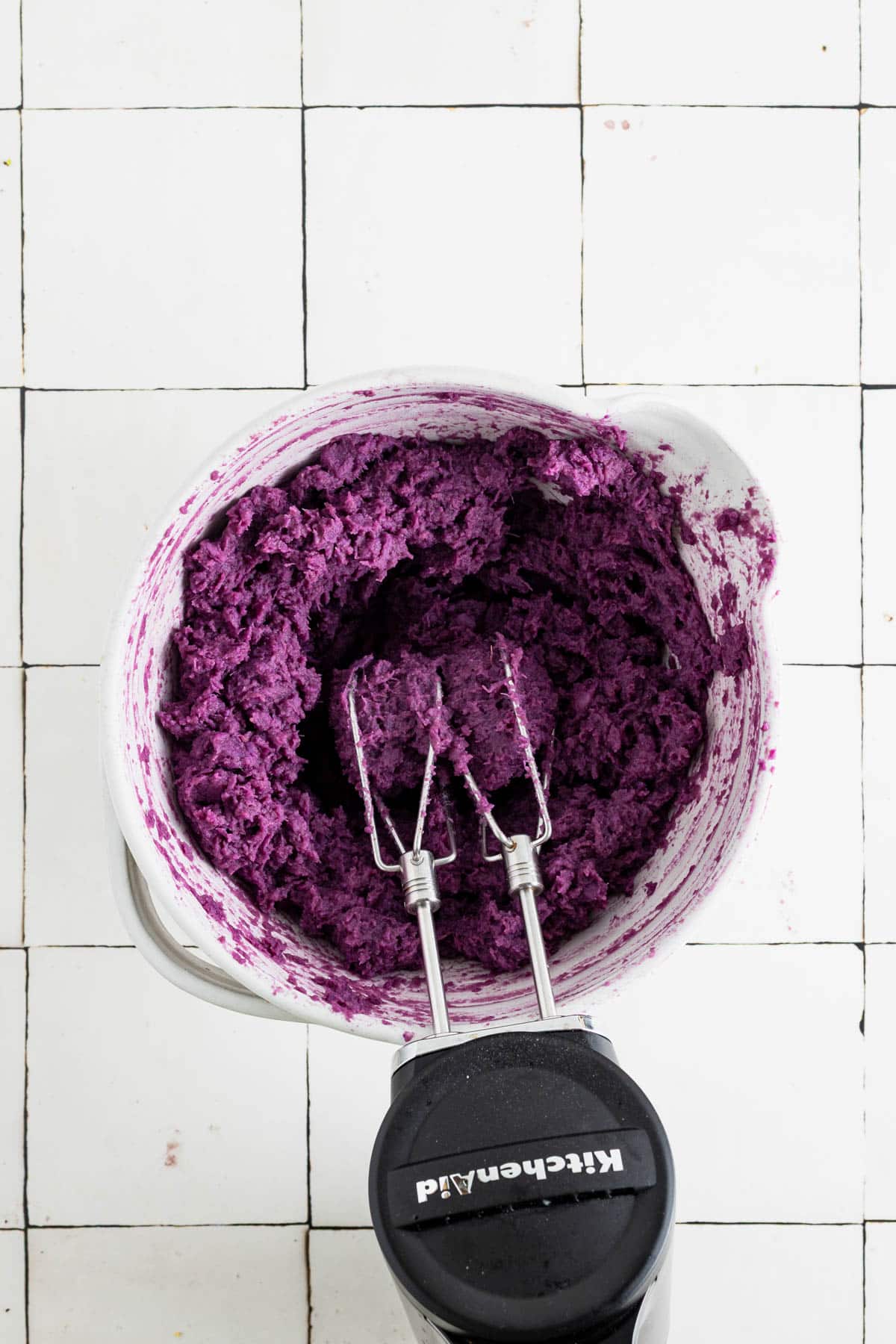 Whipping sweet potatoes with a hand mixer.