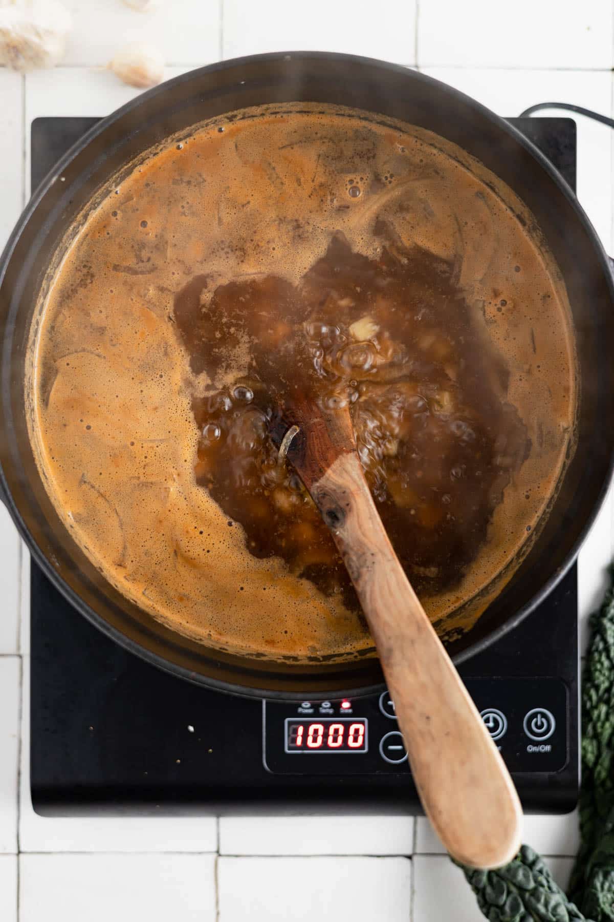Kale and chickpea soup boiling in a soup pot.
