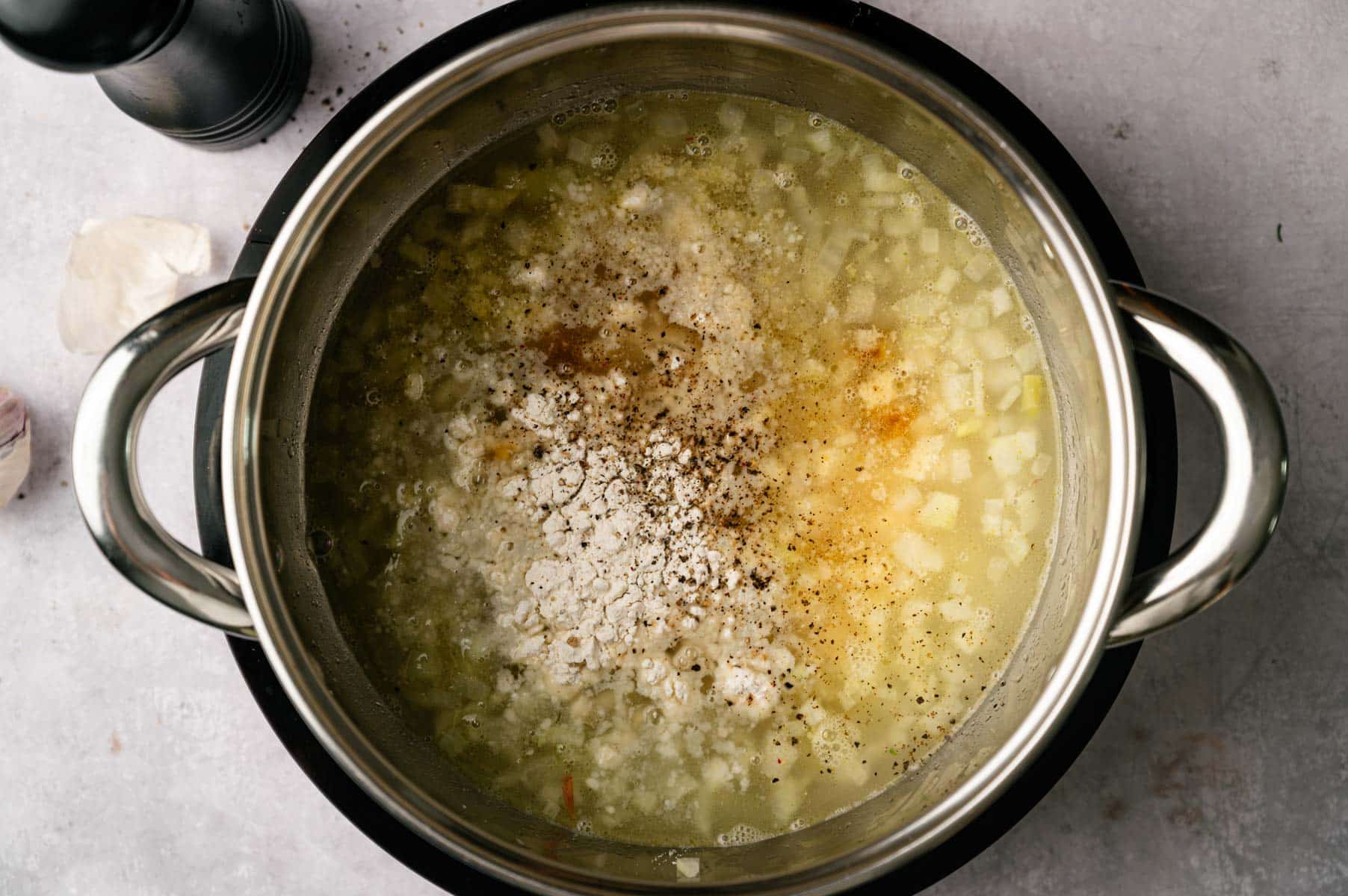 Spices and herbs added to the stainless steel pot.