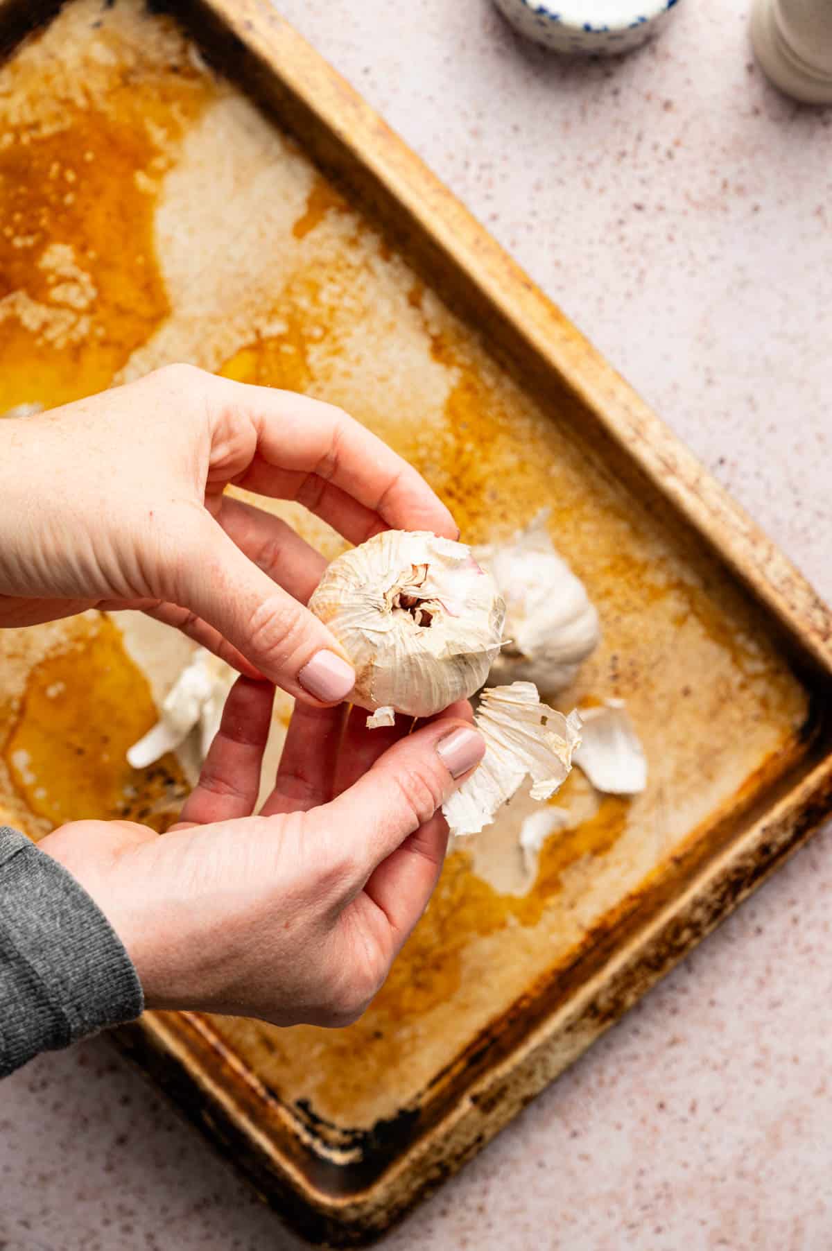 Taking loose paper off garlic bulb.