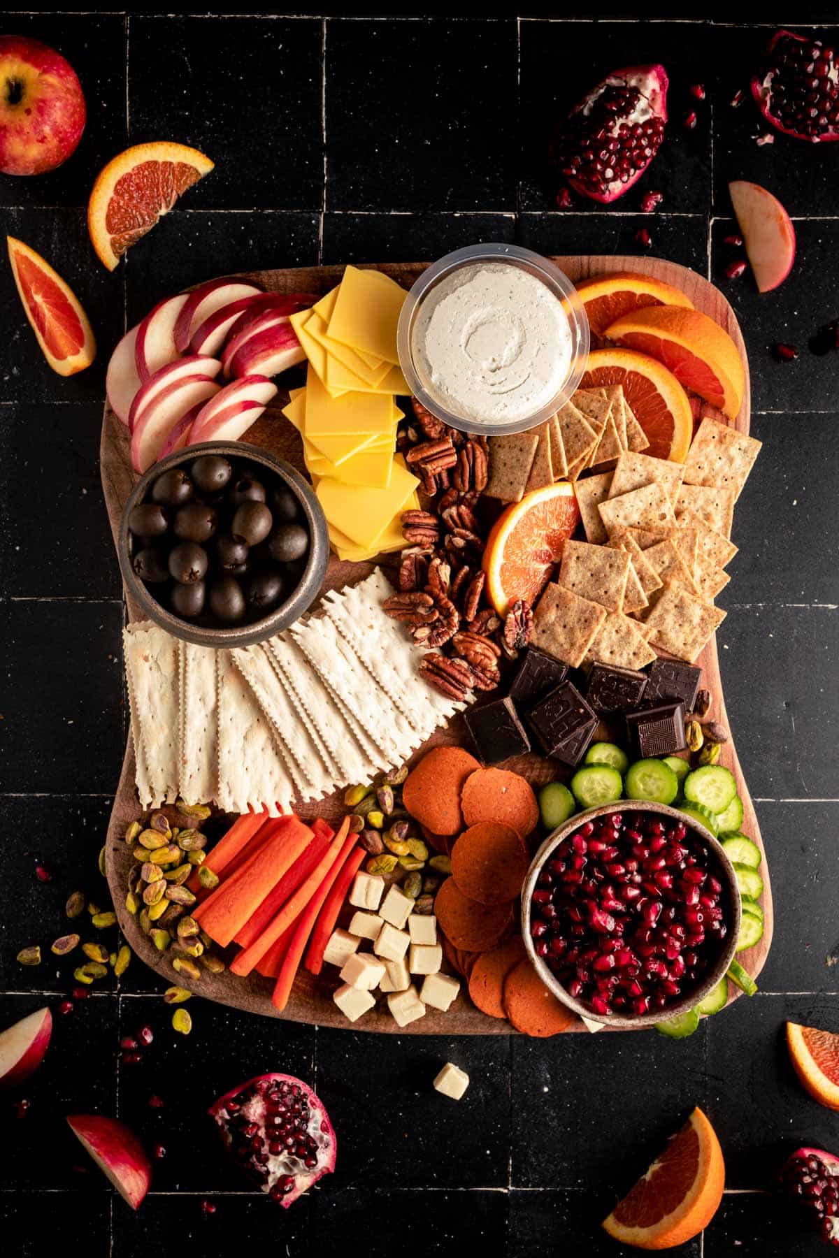 Chocolate and nuts added next to the fruits, veggies, crackers, and vegan cheeses.