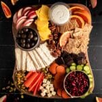 Chocolate and nuts added next to the fruits, veggies, crackers, and vegan cheeses.