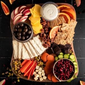 Chocolate and nuts added next to the fruits, veggies, crackers, and vegan cheeses.