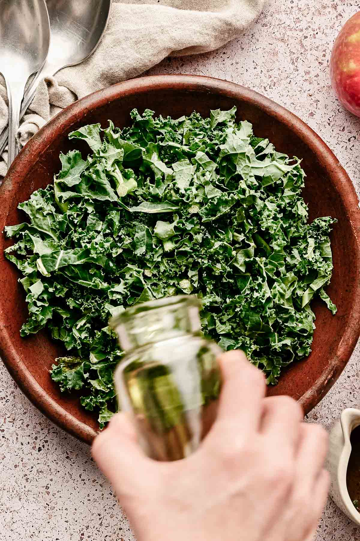 Pouring oil over kale to massage it.