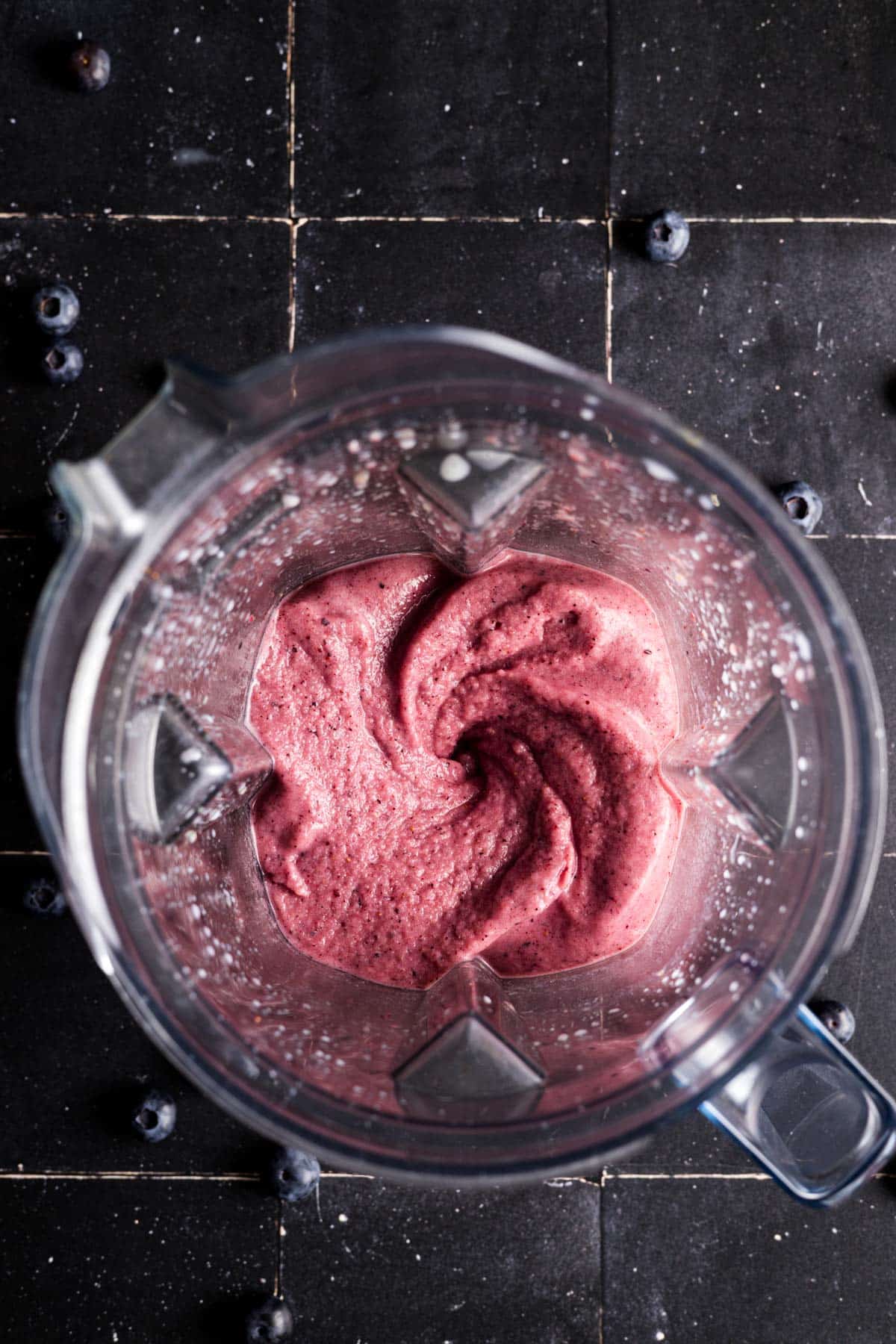 Pink smoothie blended up smooth in a blender pitcher.