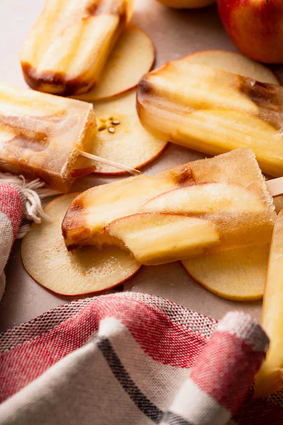 Apple popsicles with a bite taken out of one.